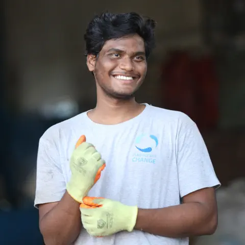 plastics for change worker smiling with gloves on